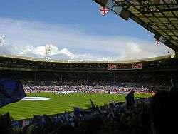 A full football stadium on a clear, bright day