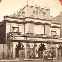 Photograph of the building in a different alteration, with a few people in front watching the photo being taken