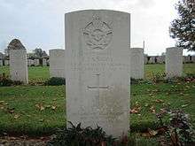 Colour photo of a grey gravestone marked with the Royal Australian Air Force crest and details of Pilot Officer F.J. Knight. Several rows of other evenly spaced gravestones are visible behind it.