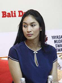 A colour photograph of a woman in a blue shirt, looking left.