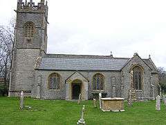 Gray stone building with square tower and slate roof.