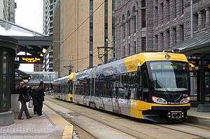 Yellow light rail across the street from old city hall downtown