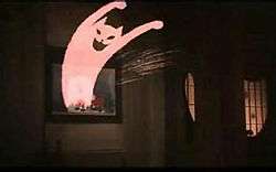 A cartoon like image of a grinning cat leaps out of a picture of Blanche in the aunt's house