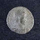 A smaller silver coin in the centre a head – still a fairly round coin but the inscription is not intact and there is no space between it and the rim