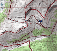 A topographic map of the pass showing Highway 82, the Continental Divide and the national forest boundaries in red on a white background with green areas