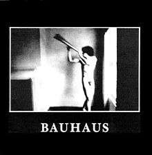 The album cover has a black background with a square in the middle featuring a black-and-white image of a naked man posing with a metal object. Below this is captioned "Bauhaus" in white text.