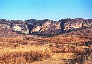 Pastel striated stone outcroppings jut from the plains