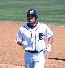 A baseball player in uniform runs across the infield.