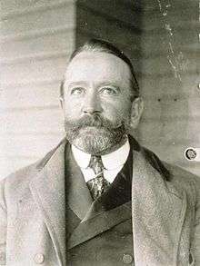 Back and white photo of a man wearing a suit and a bow tie