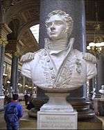 Bust of a curly-haired man wearing a uniform with epaulettes.