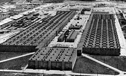 Oblique aerial view of an enormous U-shaped building.