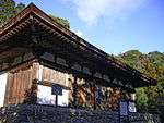 Wooden building on a stone platform with white walls.