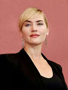 Kate Winslet facing left smiling with a pink background