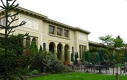 Photograph of a multi-arched entry to a large, single-story building.