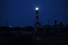 Red-and-white lighthouse at night