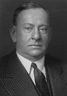 Face portrait of clean shaven man in suit in a black and white photo.