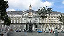 A large stone building with a clock tower on its roof.