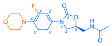 Skeletal formula of N-{[(5S)-3-[3-fluoro-4-(morpholin-4-yl)phenyl]-2-oxo-1,3-oxazolidin-5-yl]methyl}acetamide, highlighting the morpholino and fluoro groups in orange, with the rest in blue. The carbon atoms of the parent chain are numbered.