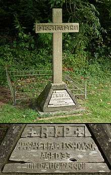 A wooden cross in the shade of a tree