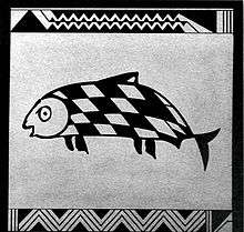 Photo of square side of pottery showing fish with skewed checkered pattern on its skin. Zig-zag lines represent waves at the top and bottom.