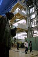 Patrons walking towards door in modern lobby with 19th C. bronze sculpture of Minerva by Jakob Fjelde on left