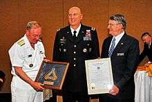 Rear Admiral James (Phil) Wisecup, President of the U.S. Naval War College and Rear Admiral (Ret) Glenn E. Whisler, Jr., Chairman, Naval War College Foundation Board of Trustees, present General Raymond T. Odierno, Commander, Multi-National Force-Iraq and Operation Iraqi Freedom with the Naval War College Distinguished Graduate Leadership Award at the Naval Support Activity Washington – Washington Navy Yard Catering and Conference Center. (U.S. Navy photo by Joseph P Cirone/Released).