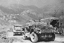 Reconnaissance car going uphill, followed by another car