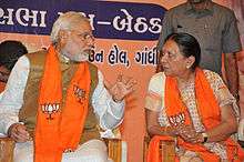 Modi talking to a woman; both are seated.