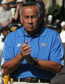 Coach Chow clapping his hands in a blue shirt before a game.