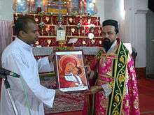 Two men holding an icon in front of an altar