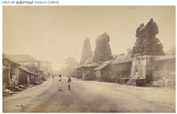 Streets of the town with three temple towers in the right facing houses in the left