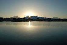 Sunrise over mountains in the background and a lake in the foreground