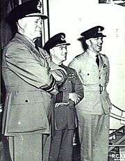 Three men in light-coloured military uniforms with peaked caps