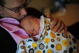 Father holding daughter in swaddling clothes