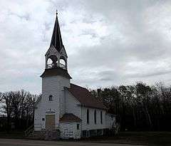 White frame church with bell tower and steeple