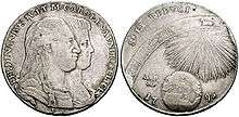 Two heads appear on a grey coin surrounded by Latin text