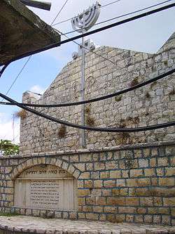 A tall, white bricked, domed building against a blue sky.