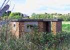 Low-slung reinforced gun emplacement, with two long horizontal gun-slit windows, c. 2008.