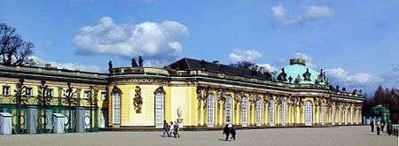 Single story pale yellow ornate palace stretching from the left foreground to the right background.