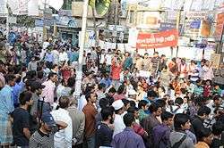 Large crowd (mostly male) with banners in street