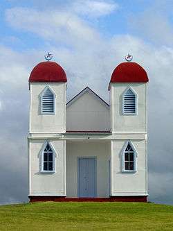 Simple white building with two red domed towers