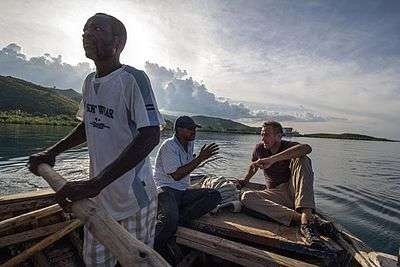 Photo of Urbina on rowboat with two other men