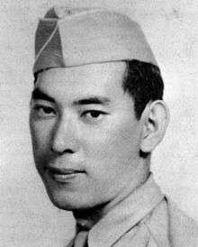 Head of a man wearing a garrison cap and a light colored shirt and tie.