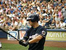 Ryan Braun, wearing a dark blue Brewers uniform, yields a baseball bat