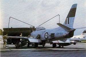 Single-engined fighter jet being refuelled from tanker truck