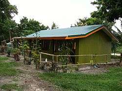 A small modern building with a metal room and painted green walls