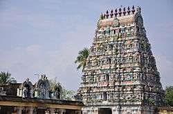 A lozenge-shaped tower tapering towards the top. It is covered in carvings including human figures and has an ornamental roof.