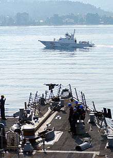 Smaller military boat passing a larger one