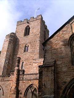 A stone church building with a tower. A Saltire flag flies on a pole on the top of the tower.