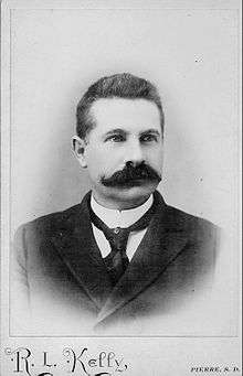 Head and shoulders of an unsmiling 39 year old man with a walrus moustache in 1895